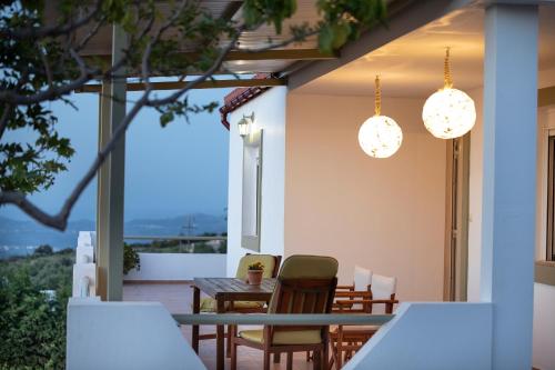 un patio con mesa, sillas y luces en Rural Residence en Skouloúfia