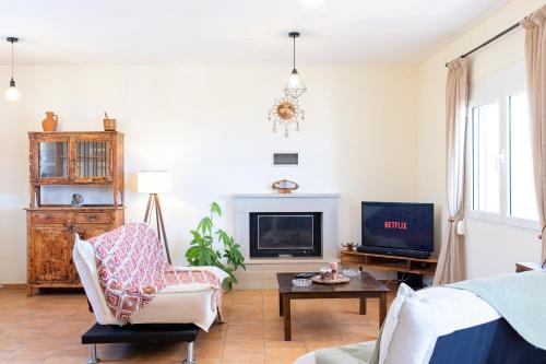 a living room with a couch and a tv at Rural Residence in Skouloúfia