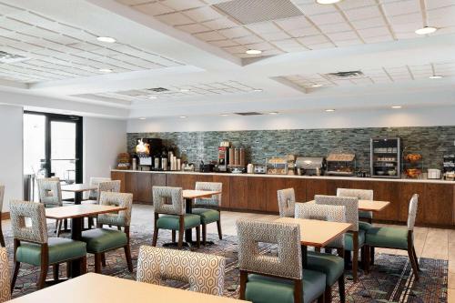 a restaurant with tables and chairs and a counter at La Quinta by Wyndham Omaha Airport Downtown in Omaha