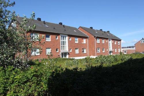 ein großes rotes Backsteingebäude mit weißen Fenstern in der Unterkunft Moin Moin in Hörnum