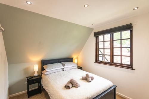 a bedroom with a bed with two pillows and a window at Cornwall holiday homes in Hayle
