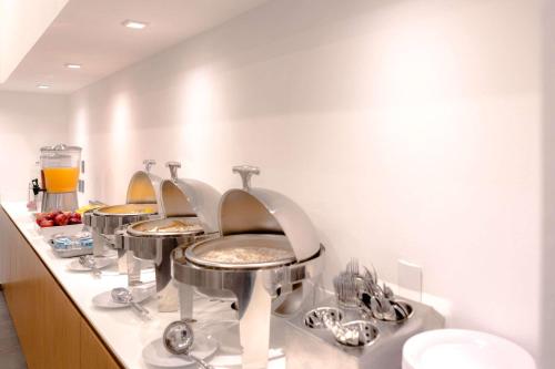 a row of sinks in a bathroom with mirrors at Sleep Inn Guadalajara Galerias in Guadalajara