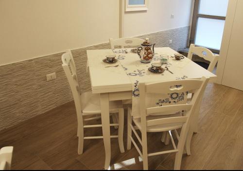 a dining room table with white chairs and a white table and chairsearcher at Il Casale del Borgo in Cancellara
