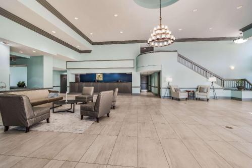 a lobby with chairs and tables and a staircase at MainStay Suites Florence - Darlington in Florence