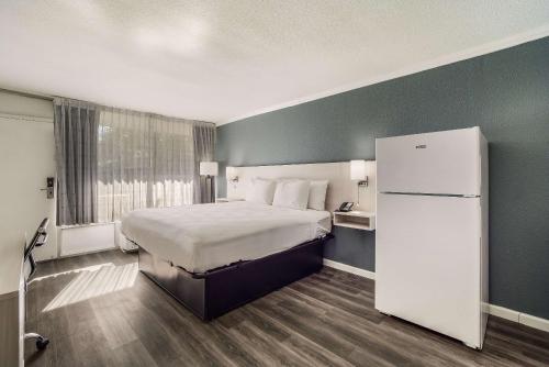 a hotel room with a bed and a refrigerator at MainStay Suites Florence - Darlington in Florence