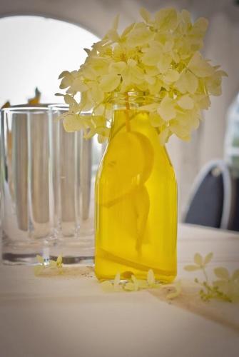 a yellow vase with flowers in it on a table at Landhotel Möllhagen in Schülp