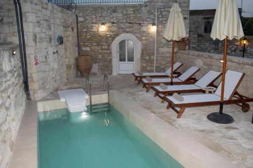 una piscina con tumbonas y una piscina en Margarita Mansion, with private heated pool!, en Kalandares