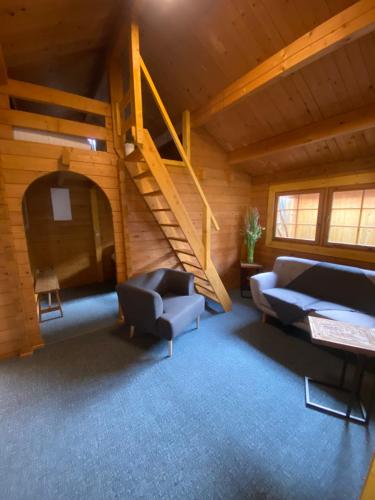 a living room with two couches and a staircase at Pension Villa Ostseetraum in Warnemünde