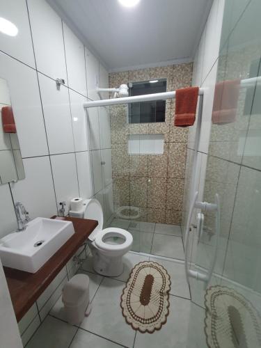 uma casa de banho com um WC, um lavatório e um chuveiro em Flat da Praia de Tarituba 2 em Paraty