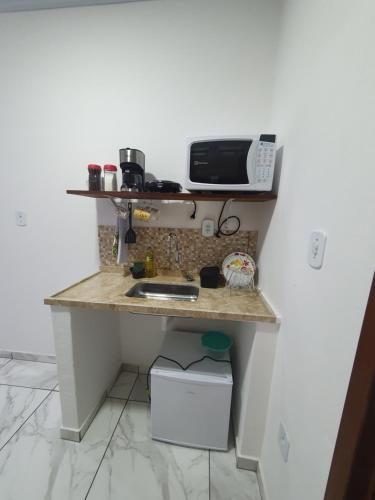 a kitchen counter with a microwave on top of it at Flat da Praia de Tarituba 2 in Paraty