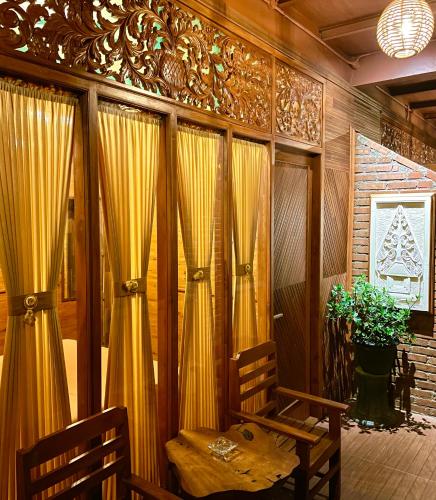 a room with two wooden chairs and curtains at Bagas Luxury Camp Telaga Menjer in Kejajar