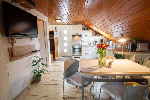 una pequeña cocina con una mesa con un jarrón de flores. en Holiday Home Linda en Liptovský Mikuláš