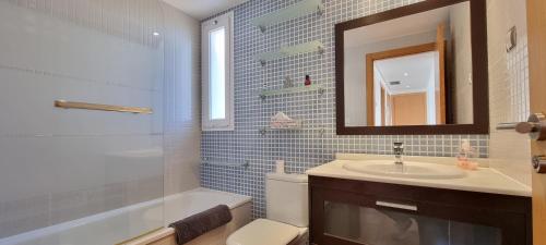 ein Badezimmer mit Waschbecken, Toilette und Spiegel in der Unterkunft Homes of Spain, Atico Lomas del Mar V con vistas al mar y solárium grande, WIFI in Playas de Vera