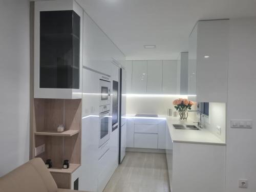 a white kitchen with a sink and a refrigerator at Casa Viento de Levante in Cádiz