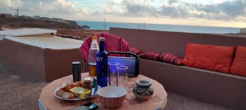 - une table avec des bouteilles de vin et un bol de nourriture dans l'établissement Les Étoiles du Ksar, à Mirleft