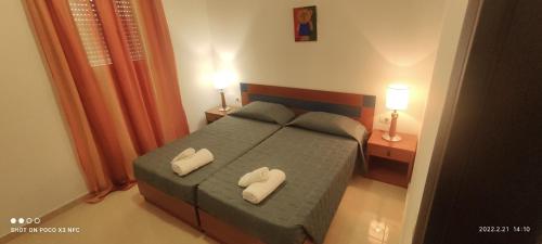 una camera con un letto con due cuscini sopra di Diamond Deluxe Apartments Mastichari a Mastichárion
