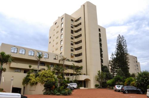 a large building with cars parked in a parking lot at 307 Bermudas - by Stay in Umhlanga in Durban