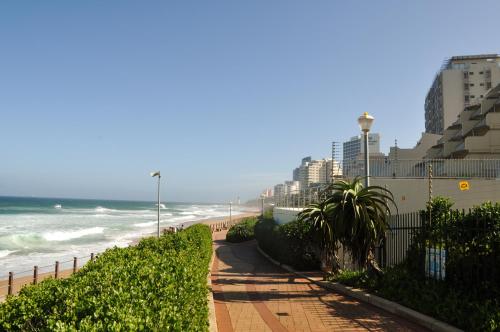 una playa de arena con edificios y el océano en 307 Bermudas - by Stay in Umhlanga en Durban