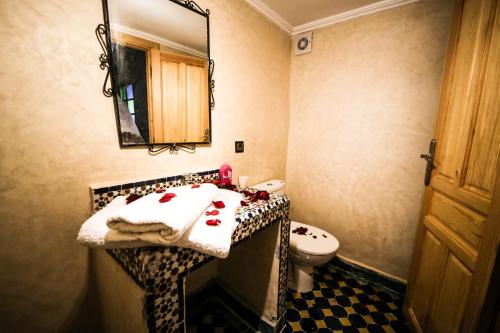 a bathroom with a sink and a toilet and a mirror at Riad Fes EL KAID in Fez
