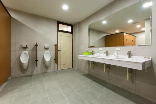 a bathroom with two urinals and a sink at 藏風民宿THE WIND GUESTHOUSE 2022 in Tainan