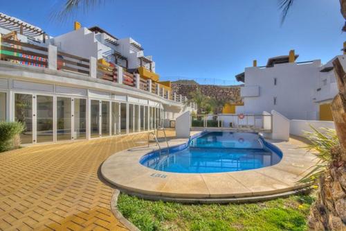 ein Haus mit einem Pool vor einem Gebäude in der Unterkunft Homes of Spain, Atico Lomas del Mar V con vistas al mar y solárium grande, WIFI in Playas de Vera