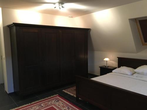 a bedroom with a bed with a large wooden headboard at Hotel La Chaumiere in Asse