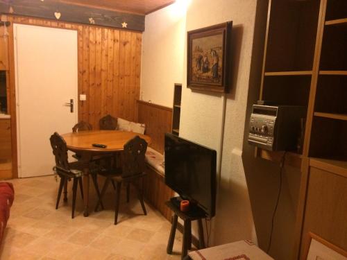 une salle à manger avec une table et une télévision dans l'établissement Chalet les trolles, aux Gets