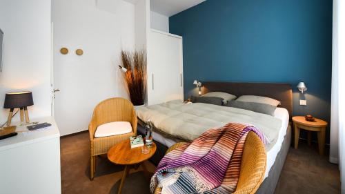 a bedroom with a bed and a table and chairs at Hotel Aquamarin in Norderney