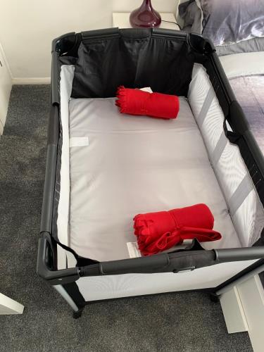 a suitcase with two red pillows on a bed at 2 bed 1st floor Apartment-own entrance & parking in Portsmouth
