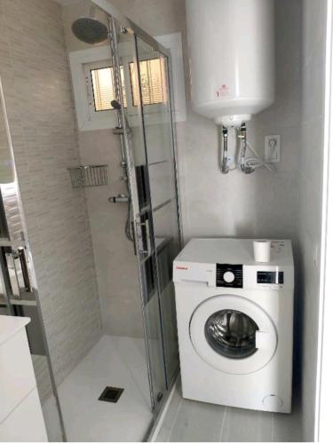 a small bathroom with a washing machine and a shower at Estudio Delicia 2 in Benalmádena