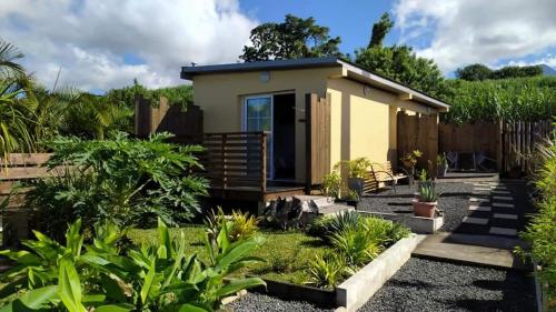 a small yellow house in a garden at La kazanou in Saint-Joseph