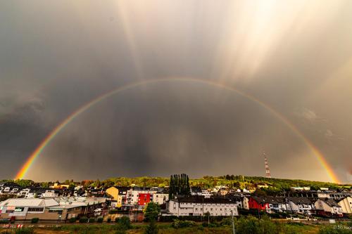 a double rainbow in the sky over a city at Cottage Logis Hôtel - Restaurant in Dudelange