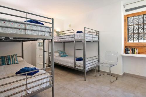 Cette chambre comprend 3 lits superposés et une chaise. dans l'établissement Playa Flamingo 34, à Playa Blanca