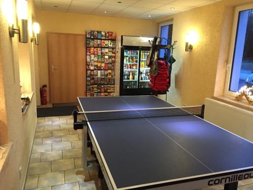 a ping pong table in a room with a drink cooler at Pension Pöhlbergblick Annaberg in Annaberg-Buchholz