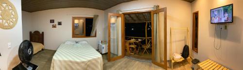 two pictures of a room with a table and a television at Mirante dos Ventos in Luis Correia