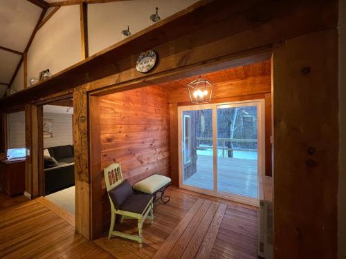 a room with a wooden wall with a window and a chair at Brookside Hideaway, Brook Road Inn in Goshen
