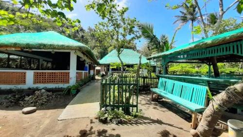eine blaue Bank, die vor einem Gebäude sitzt in der Unterkunft Zeah's Beach Place in Bulusan