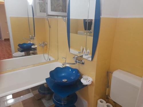a bathroom with a blue toilet and a tub at New 33 in Bacău