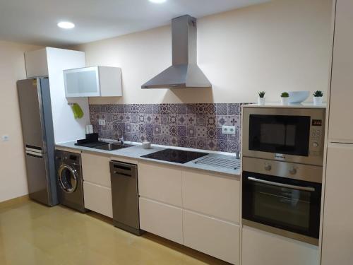 a kitchen with a stove and a refrigerator at Inmueble en Navas de Tolosa in Jaén