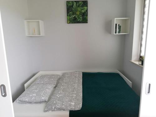 een bed in een kamer met een groene matras bij Apartament Zet in Nałęczów