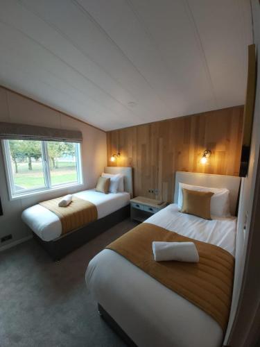 a bedroom with two beds and a window at Waters Edge Lodge with Hot Tub in York