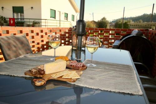 a table with two glasses of wine and cheese at Casa Nórdica in Chão de Lamas