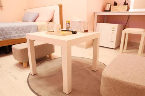 a white table in a room with a bed at Ellen House in Seoul