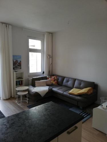 uma sala de estar com um sofá de couro e uma janela em Turmstrasse19 em Wismar