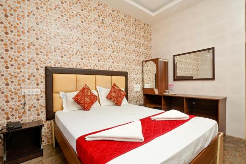- une chambre avec un lit et une couverture rouge dans l'établissement Rightchoicehotels, à Rameswaram