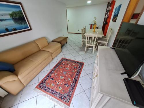 a living room with a brown couch and a table at APT Encantador Centro Guarapari, completo, 50 m da praia in Guarapari