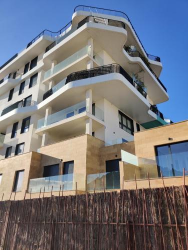 a tall white building with a fence in front of it at ALLONBAY spa & beach house in Villajoyosa