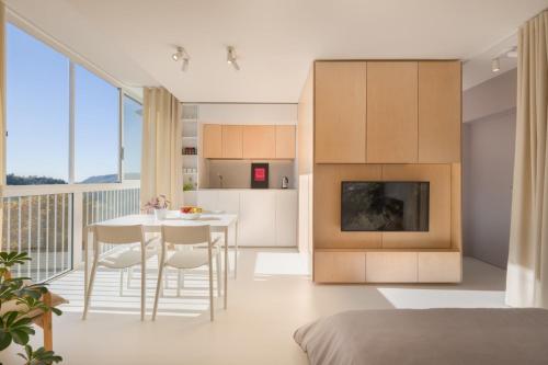 eine Küche und ein Wohnzimmer mit einem Tisch und Stühlen in der Unterkunft Elegant Studio Apartment with Panoramic View in Nova Gorica