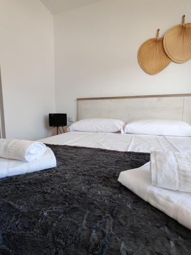 two beds with white pillows and a black carpet at ALLONBAY spa & beach house in Villajoyosa