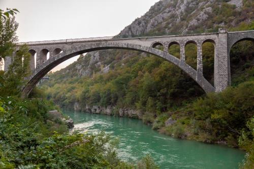 a bridge over a river with green water at Elegant Studio Apartment with Panoramic View in Nova Gorica